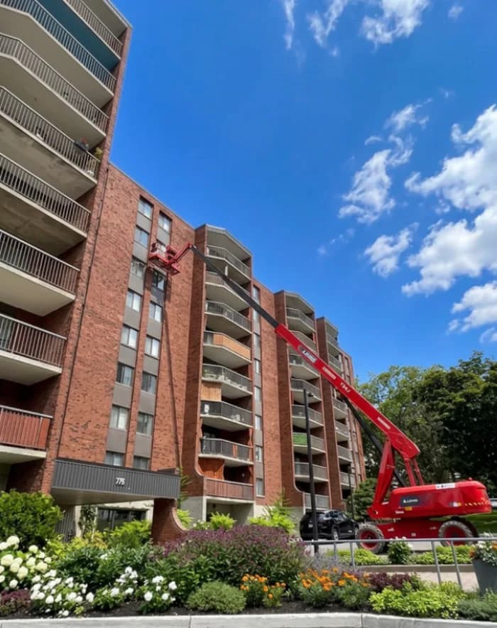 Nacelle déployée le long d'une tour à condos entourée de fleurs